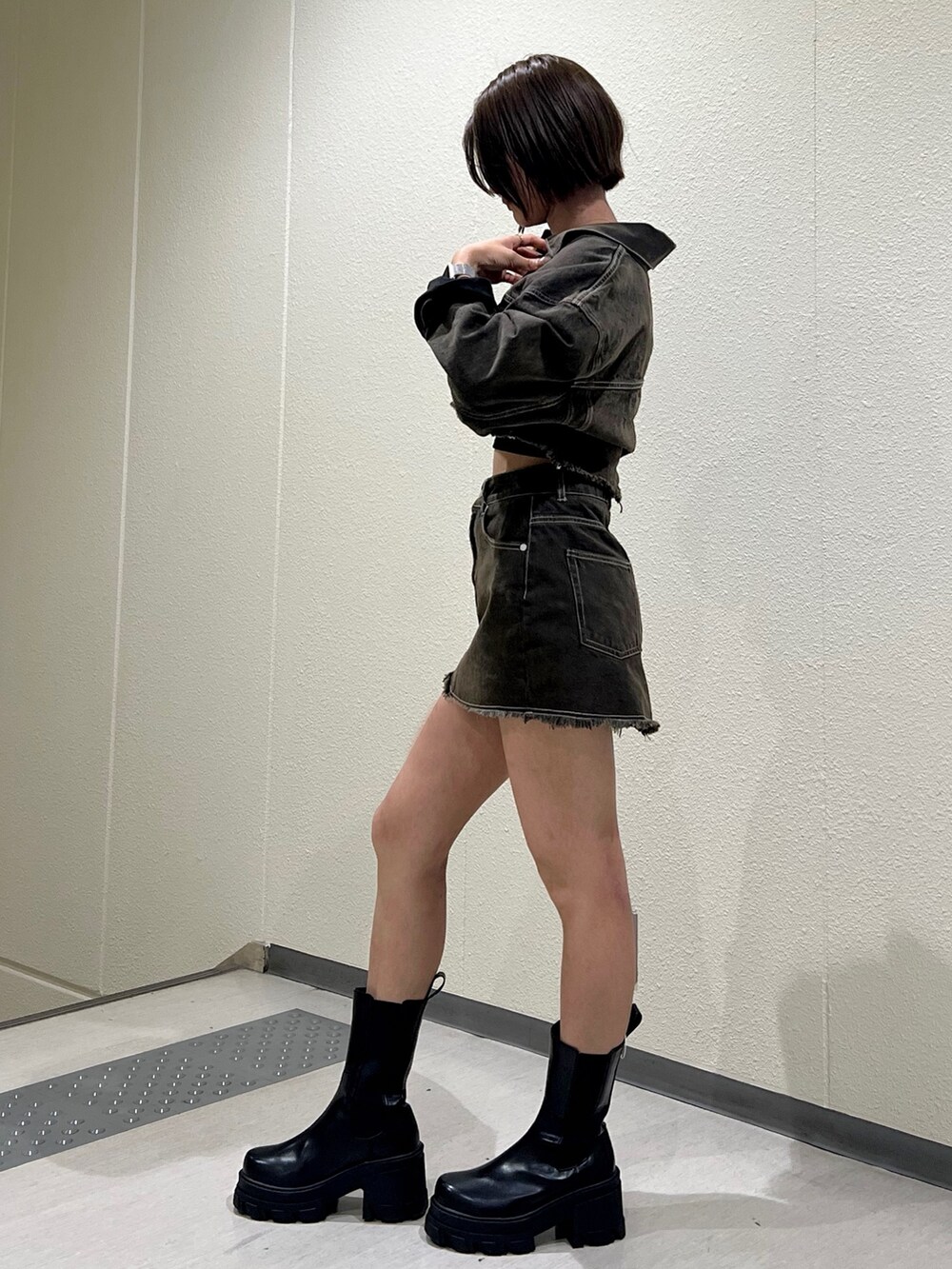 ブラウン系のデニムジャケット、ブラウン系のスカート、ブラック系のキャミソールを着用したレディースの夏コーディネートの3枚目の写真