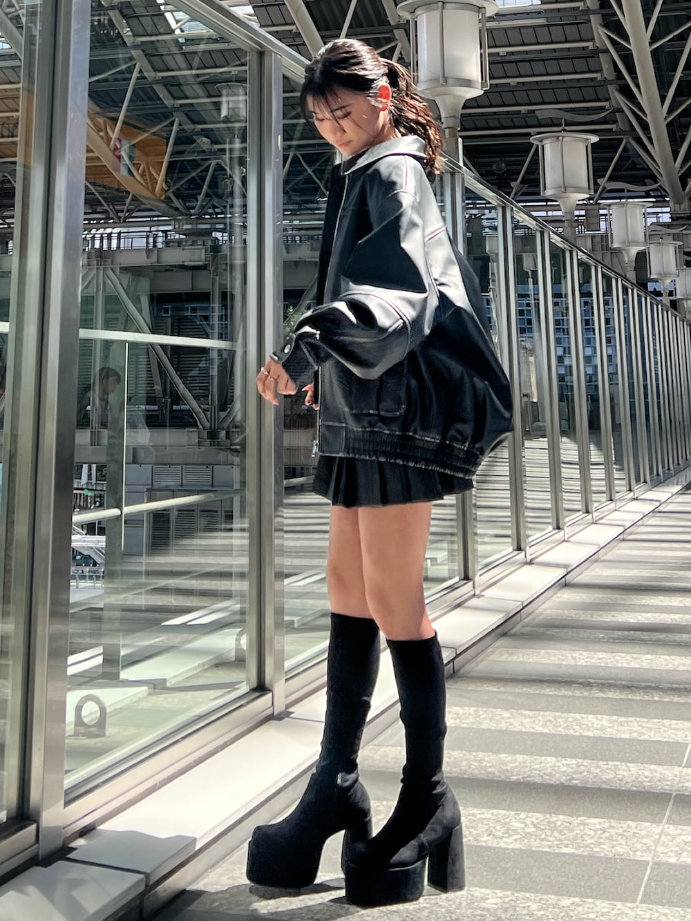 ブラック系のブルゾン、ホワイト系のキャミソール、ブラック系のスカートを着用したレディースの秋コーディネートの2枚目の写真