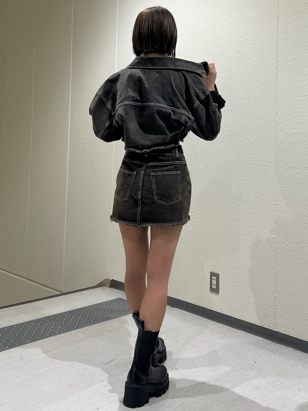 ブラウン系のデニムジャケット、ブラウン系のスカート、ブラック系のキャミソールを着用したレディースの夏コーディネートの2枚目の写真