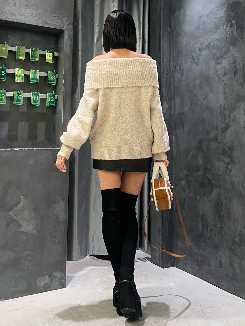 ホワイト系のニット/セーター、ブラック系のブーツ、ブラック系のスカートを着用したレディースの秋コーディネートの3枚目の写真