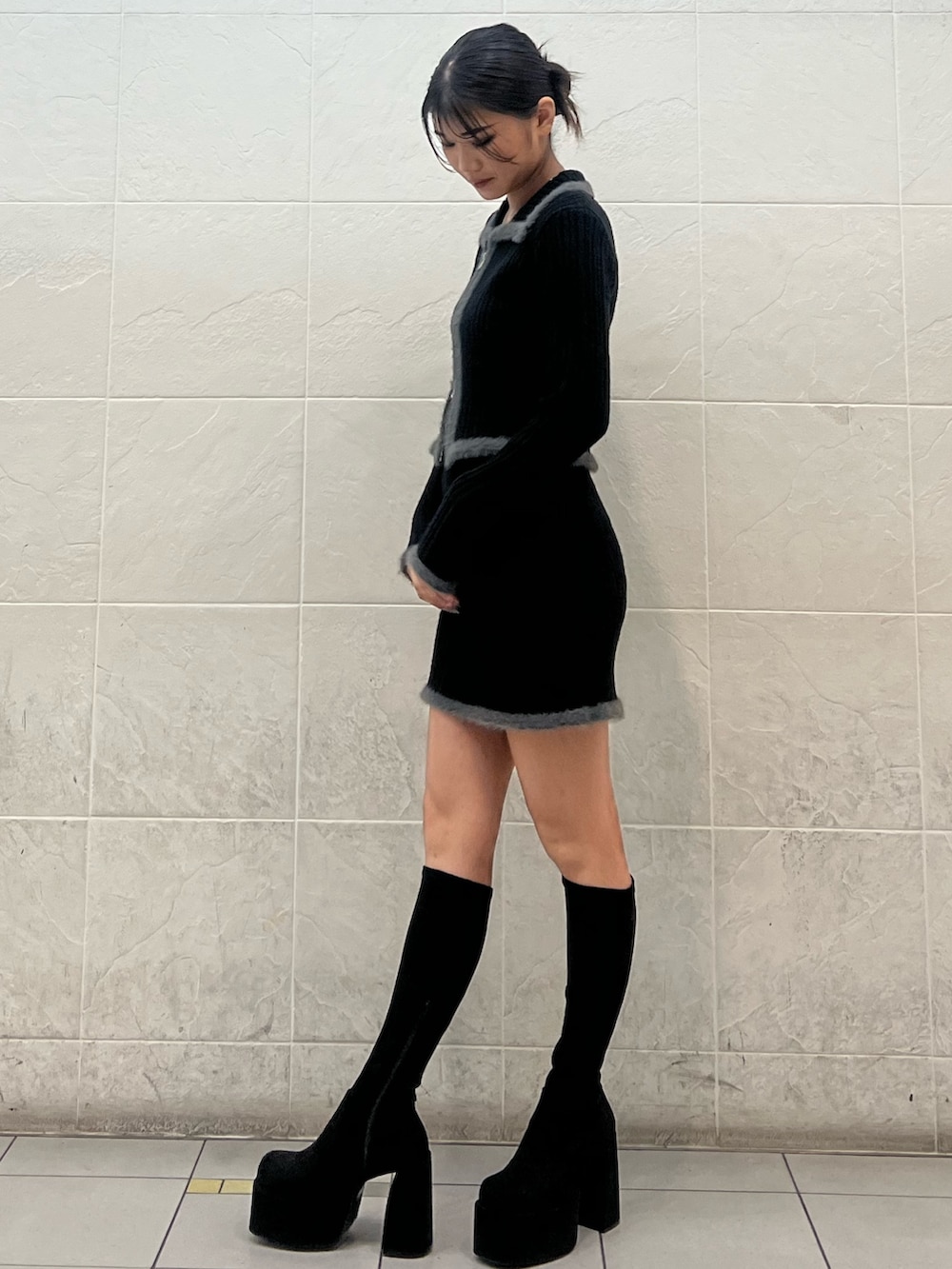 ブラック系のニット/セーター、ブラック系のスカート、その他のブーツを着用したレディースの秋コーディネートの2枚目の写真