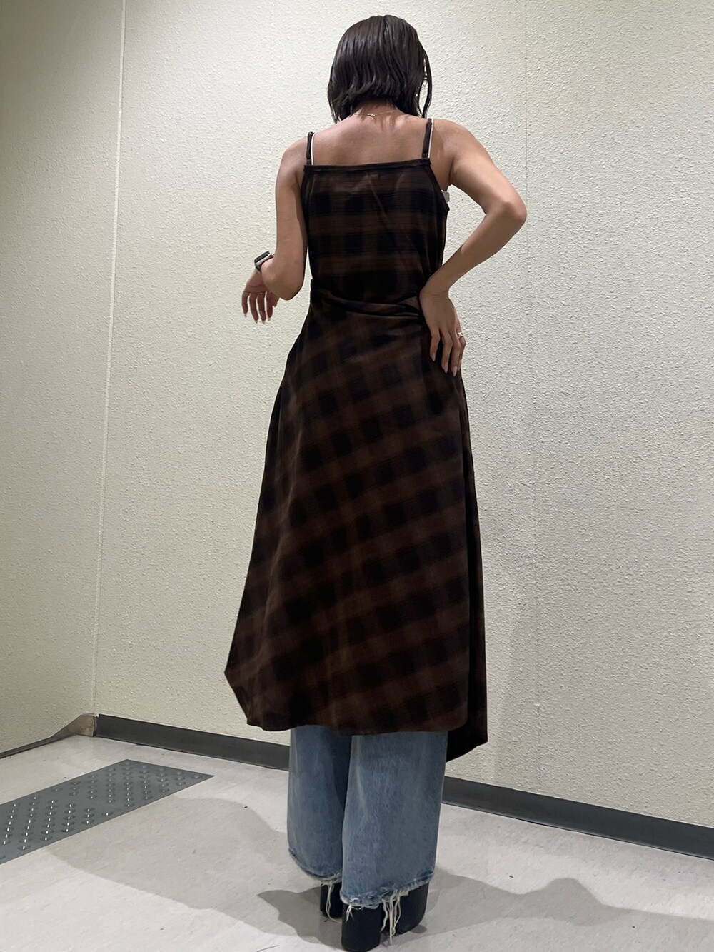 ブラウン系のワンピース、ブルー系のデニムパンツ、ブラック系のサンダルを着用したレディースの夏コーディネートの3枚目の写真