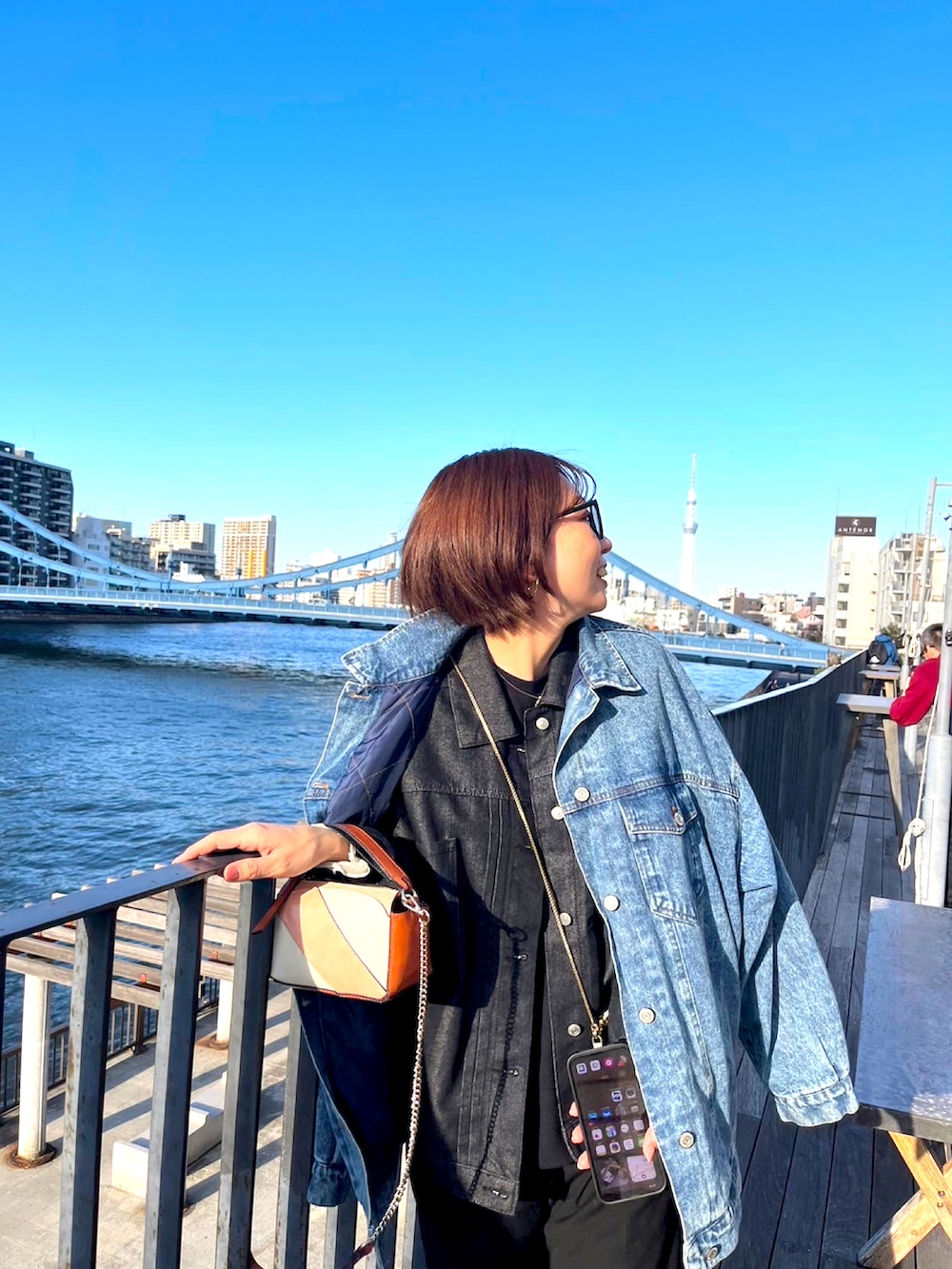 ブラック系のデニムジャケット、ブルー系のデニムジャケット、ブラック系のブーツを着用したレディースの冬コーディネートの2枚目の写真