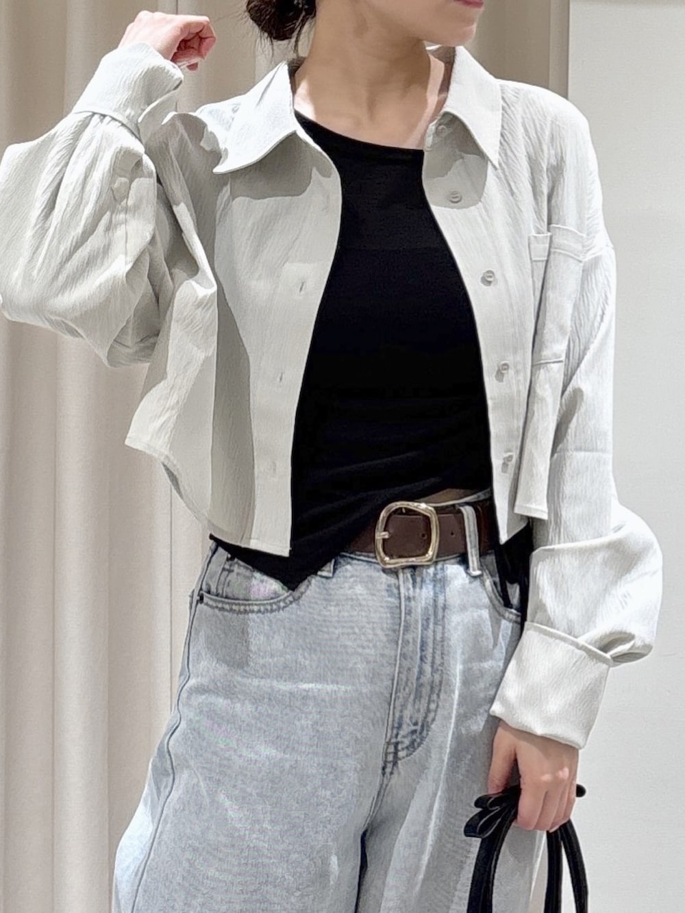 グレー系のシャツ/ブラウス、ブラック系のTシャツ/カットソー、ブルー系のデニムパンツを着用したレディースの春コーディネートの3枚目の写真