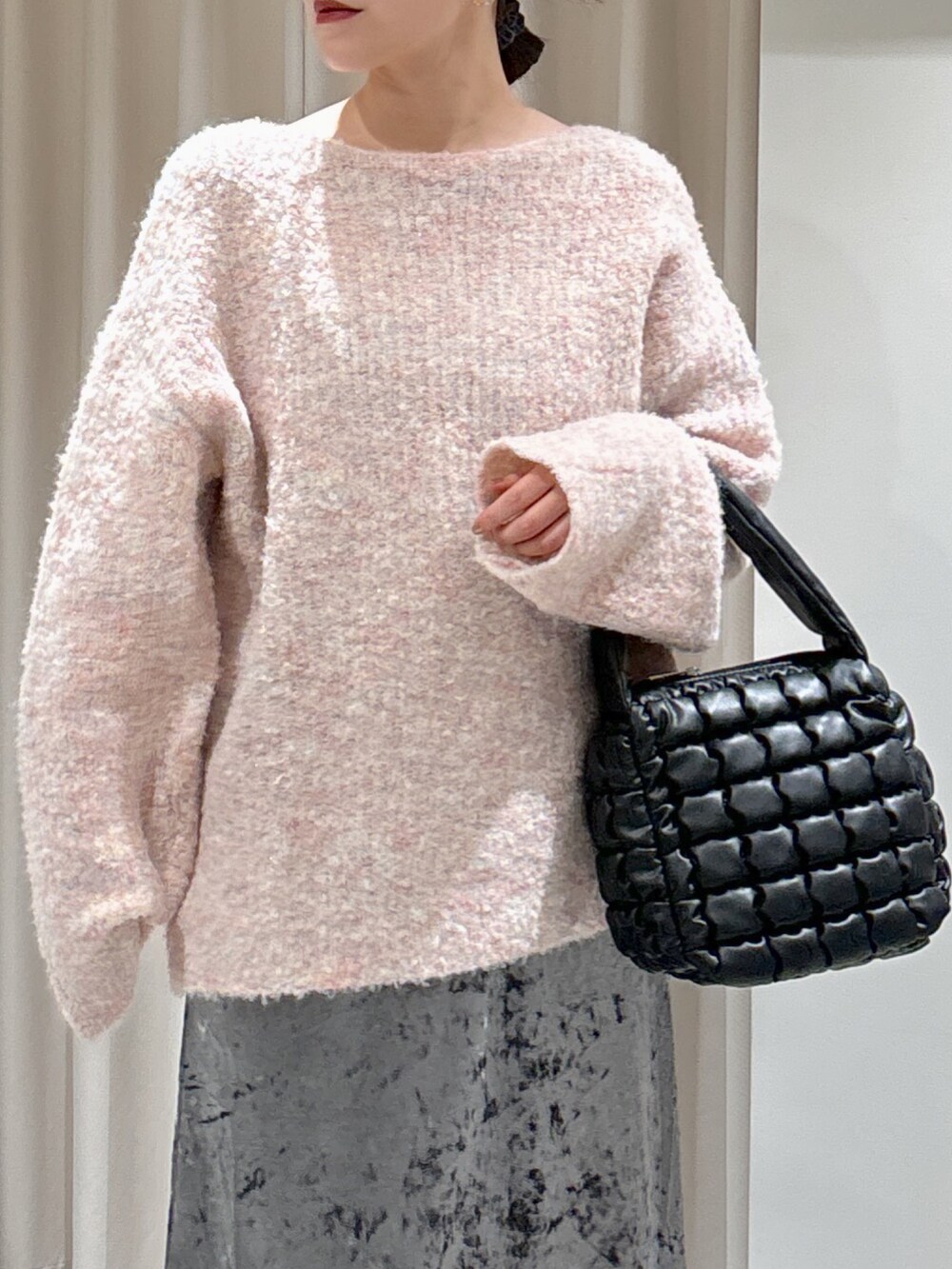 ピンク系のニット/セーター、ブラック系のハンドバッグ、ブラック系のブーツを着用したレディースの秋コーディネートの5枚目の写真