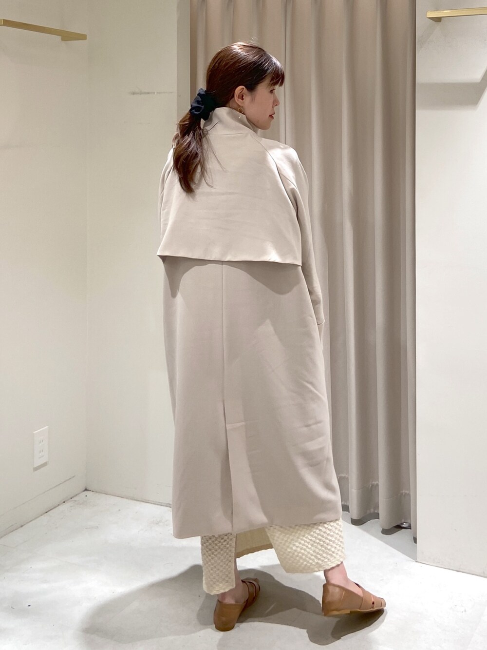 ホワイト系のトレンチコート、ブラック系のショルダーバッグ、ホワイト系のスカートを着用したレディースの春コーディネートの2枚目の写真