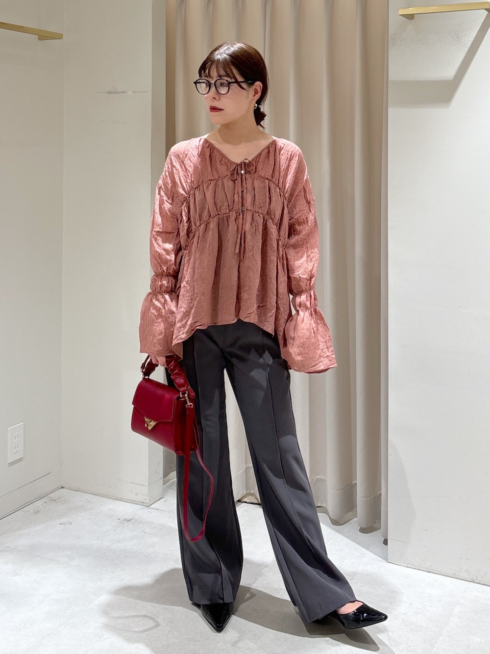 ブラック系のシャツ/ブラウス、レッド系のショルダーバッグ、グレー系のスラックスを着用したレディースの秋コーディネートの2枚目の写真