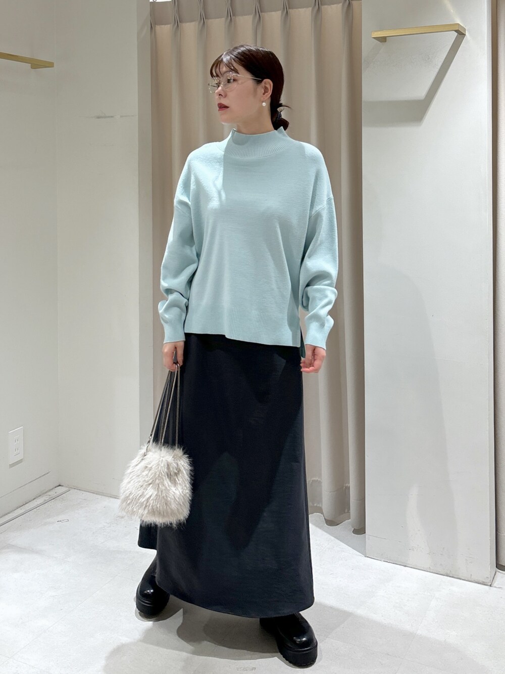 ブルー系のニット/セーター、ベージュ系のショルダーバッグ、グレー系のスカートを着用したレディースの冬コーディネートの9枚目の写真