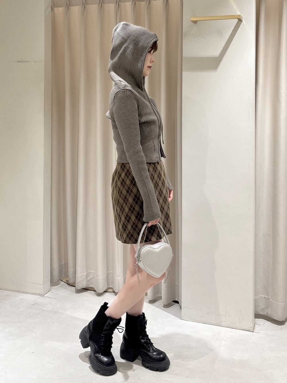 ブラウン系のニット/セーター、ブラウン系のスカート、シルバー系のショルダーバッグを着用したレディースの冬コーディネートの5枚目の写真