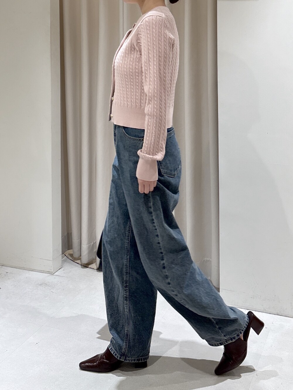 ピンク系のニット/セーター、ブラック系のショルダーバッグ、ブルー系のデニムパンツを着用したレディースの冬コーディネートの3枚目の写真