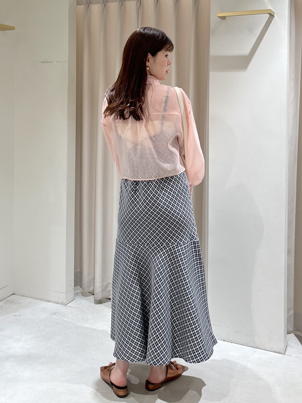 ブラック系のワンピース、ピンク系のシャツ/ブラウス、ブラウン系のサンダルを着用したレディースの春コーディネートの2枚目の写真