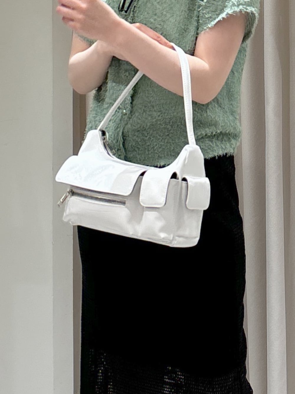 ブラック系のスカート、グレー系のサンダル、ホワイト系のハンドバッグを着用したレディースの夏コーディネートの8枚目の写真