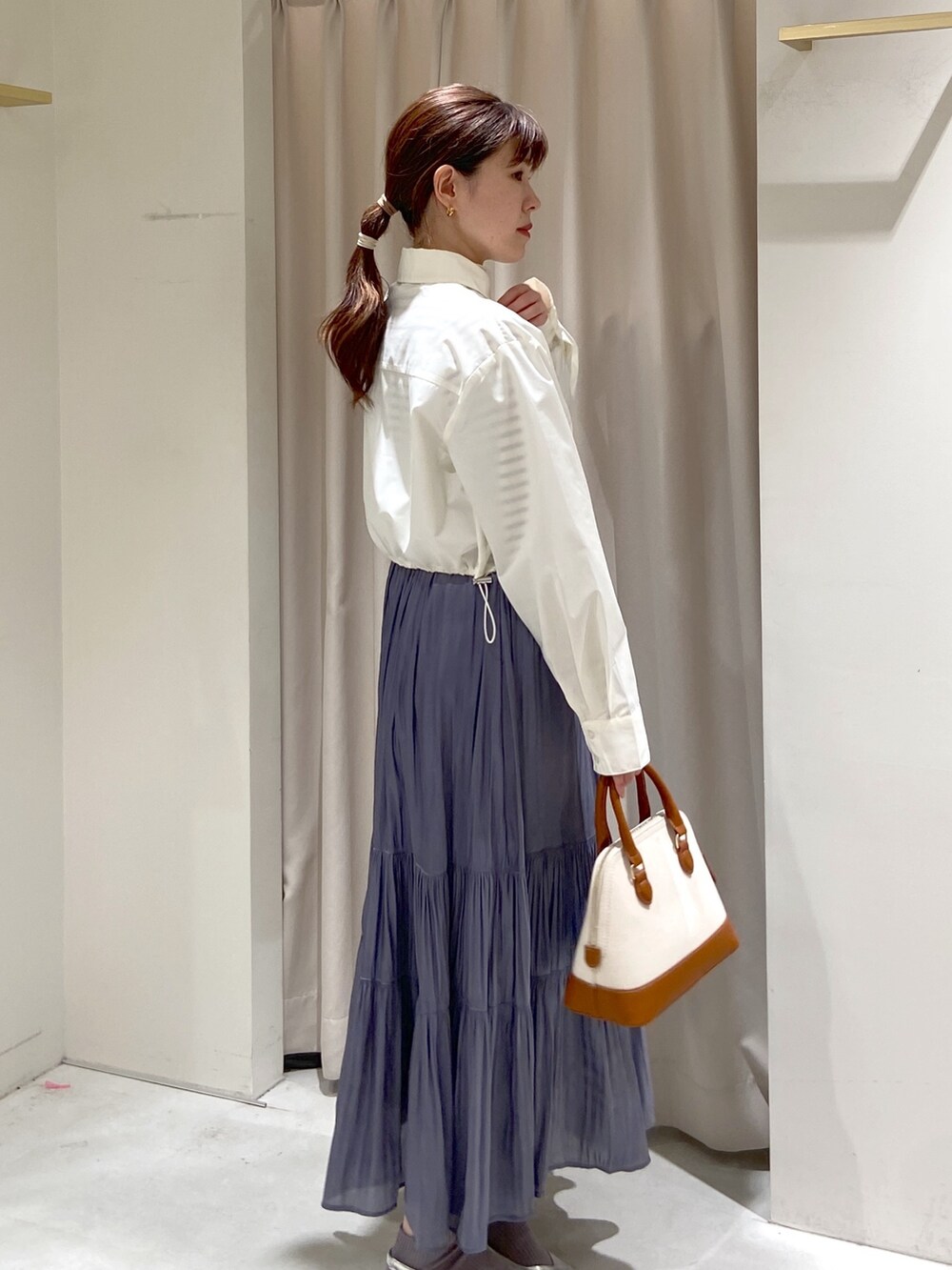 ホワイト系のシャツ/ブラウス、ホワイト系のニット/セーター、シルバー系のパンプスを着用したレディースの春コーディネートの4枚目の写真