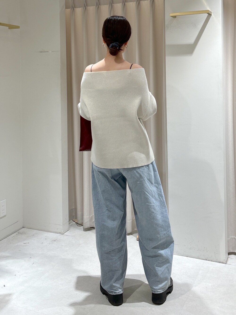 ホワイト系のニット/セーター、レッド系のショルダーバッグ、ブルー系のデニムパンツを着用したレディースの冬コーディネートの3枚目の写真