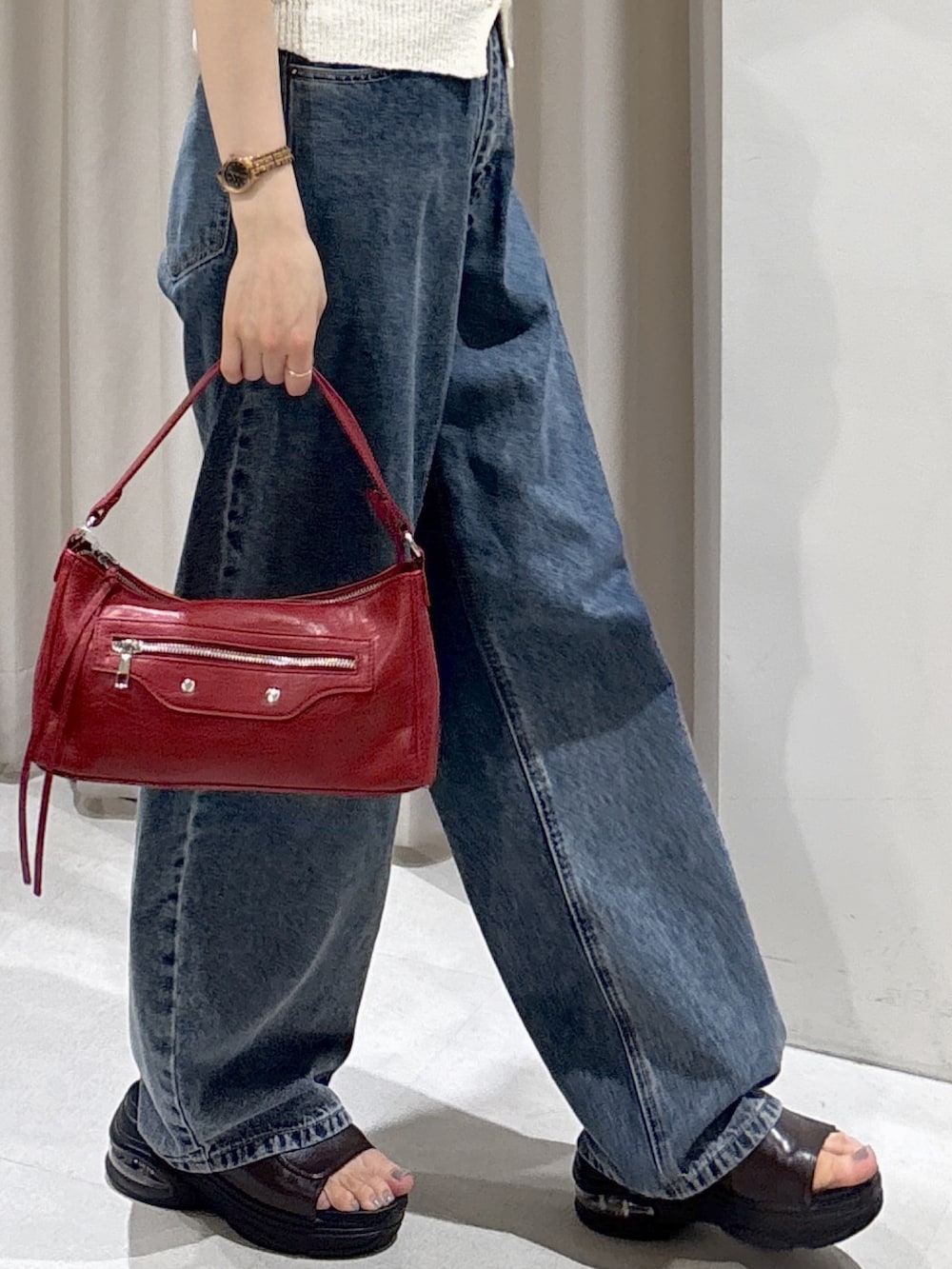 ホワイト系のニット/セーター、レッド系のショルダーバッグ、ブルー系のデニムパンツを着用したレディースの夏コーディネートの4枚目の写真