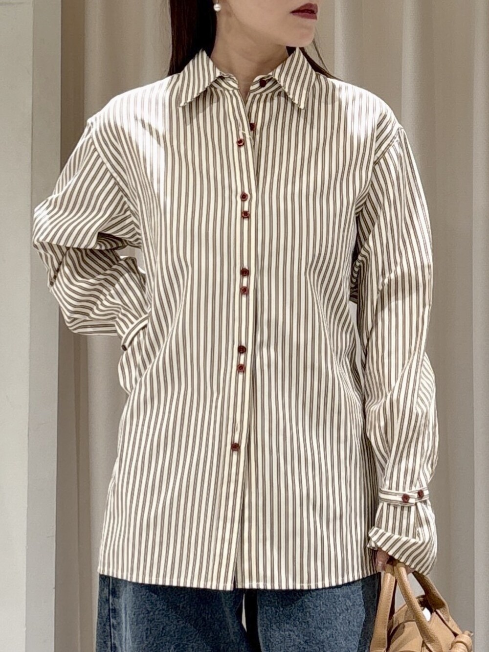 ブラック系のシャツ/ブラウス、ブラウン系のシャツ/ブラウス、ベージュ系のハンドバッグを着用したレディースの冬コーディネートの5枚目の写真