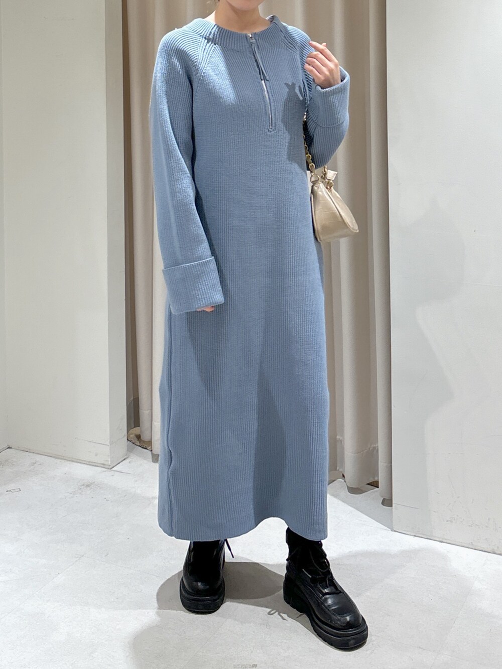 ブルー系のワンピース、ベージュ系のトートバッグ、ブラック系のブーツを着用したレディースの冬コーディネートの6枚目の写真