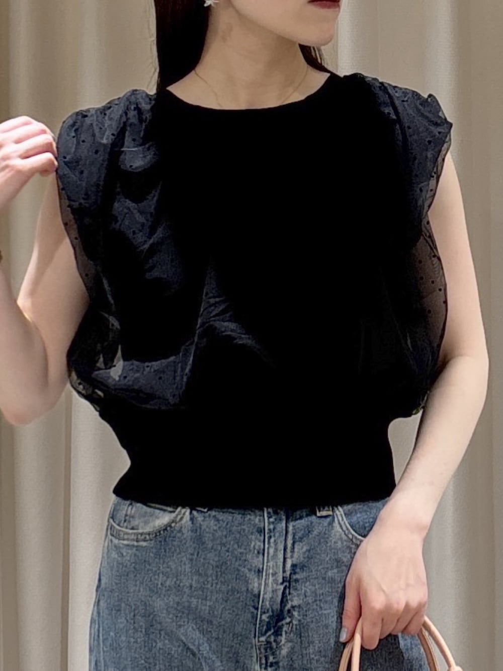 ブラック系のニット/セーター、ピンク系のボストンバッグ、ブルー系のデニムパンツを着用したレディースの夏コーディネートの4枚目の写真
