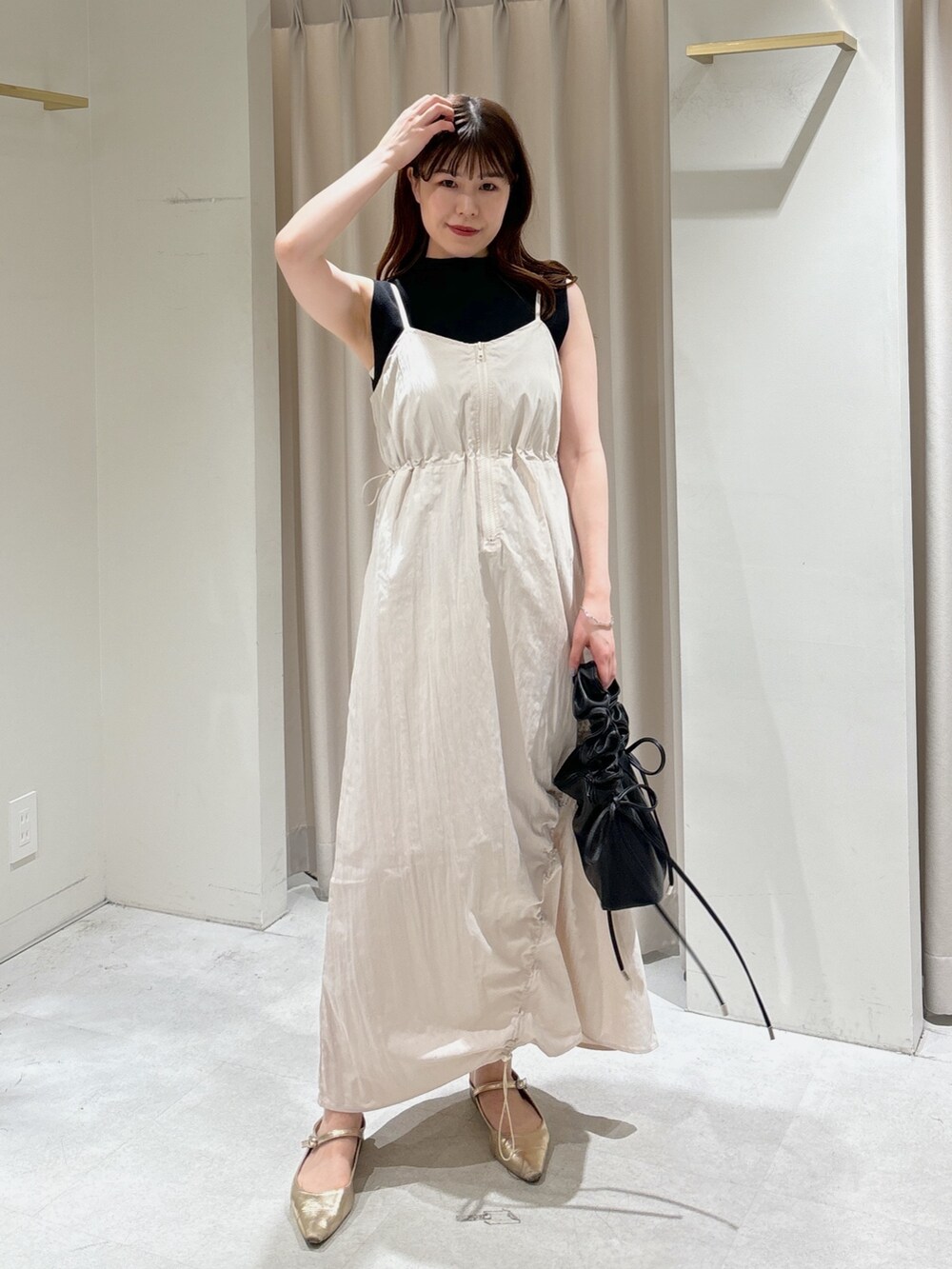 ホワイト系のワンピース、ブラック系のショルダーバッグ、ブラック系のニット/セーターを着用したレディースの春コーディネートの2枚目の写真