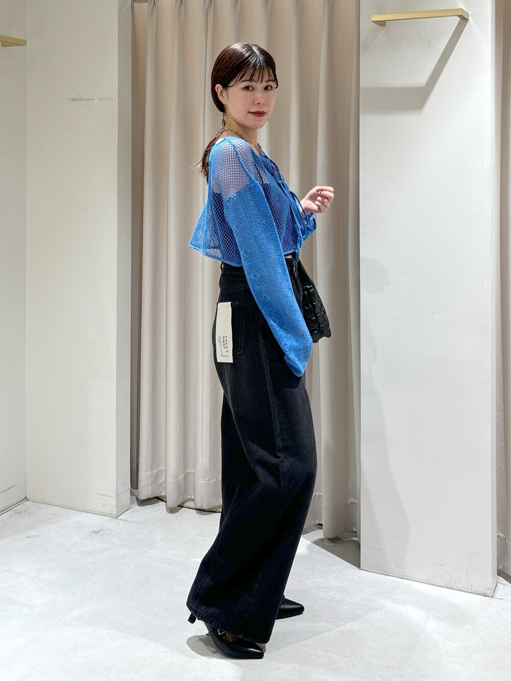 ブルー系のカーディガン/ボレロ、ブラック系のキャミソール、ブラック系のハンドバッグを着用したレディースの夏コーディネートの3枚目の写真