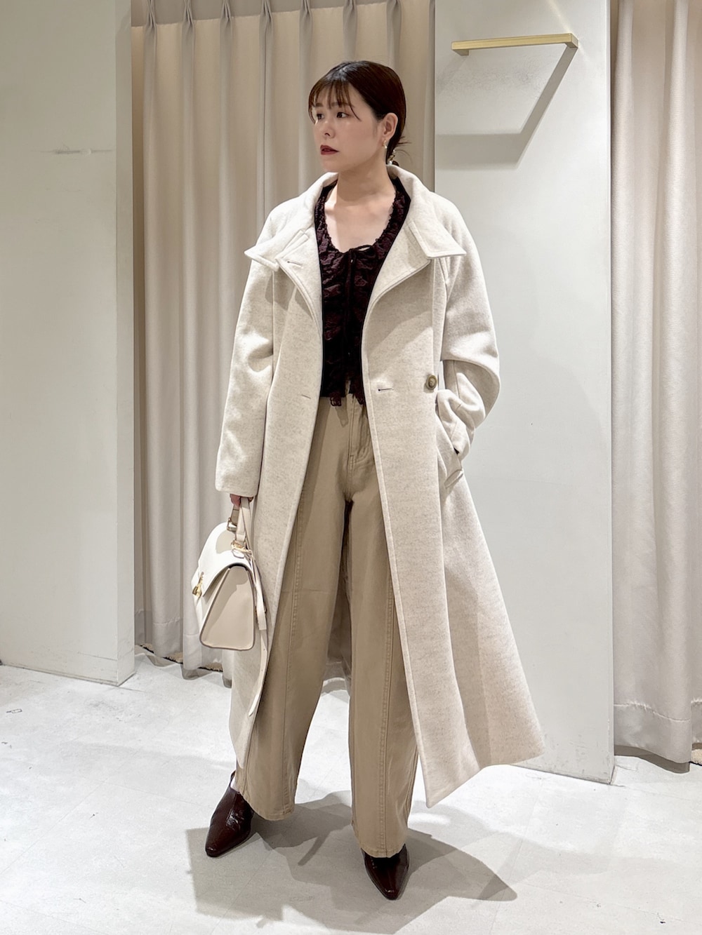 ブラウン系のニット/セーター、ベージュ系のデニムパンツ、ブラウン系のパンプスを着用したレディースの秋コーディネートの6枚目の写真