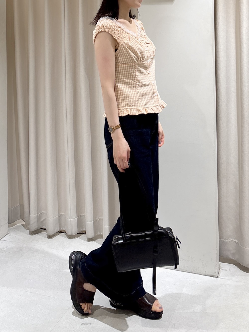 ピンク系のシャツ/ブラウス、ブルー系のデニムパンツ、ブラック系のショルダーバッグを着用したレディースの夏コーディネートの3枚目の写真