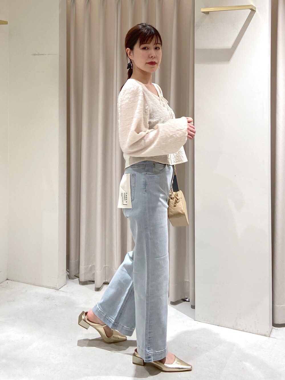 ホワイト系のシャツ/ブラウス、ブルー系のデニムパンツ、ベージュ系のボディバッグ/ウエストポーチを着用したレディースの春コーディネートの2枚目の写真