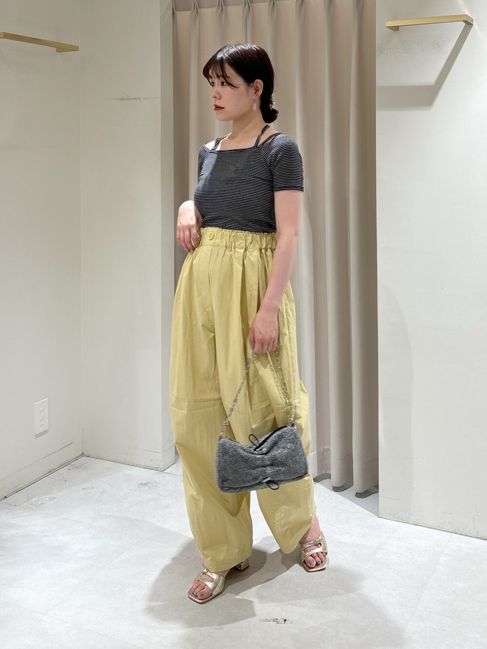 ブラック系のTシャツ/カットソー、イエロー系のその他パンツ、シルバー系のハンドバッグを着用したレディースの夏コーディネートの3枚目の写真