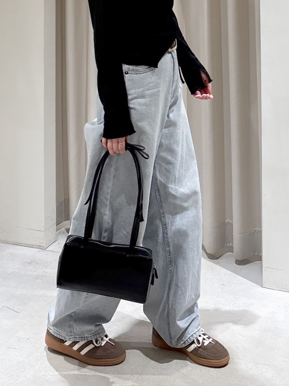 ブラック系のTシャツ/カットソー、ブルー系のデニムパンツ、ブラック系のショルダーバッグを着用したレディースの春コーディネートの6枚目の写真