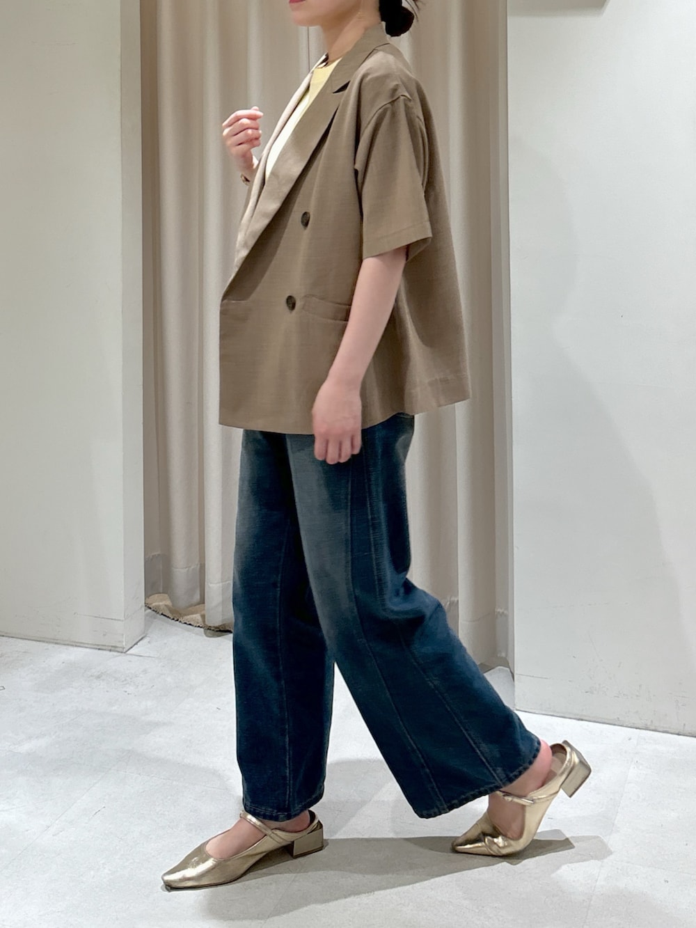 ブラウン系のテーラードジャケット、イエロー系のTシャツ/カットソー、ブルー系のデニムパンツを着用したレディースの春コーディネートの3枚目の写真