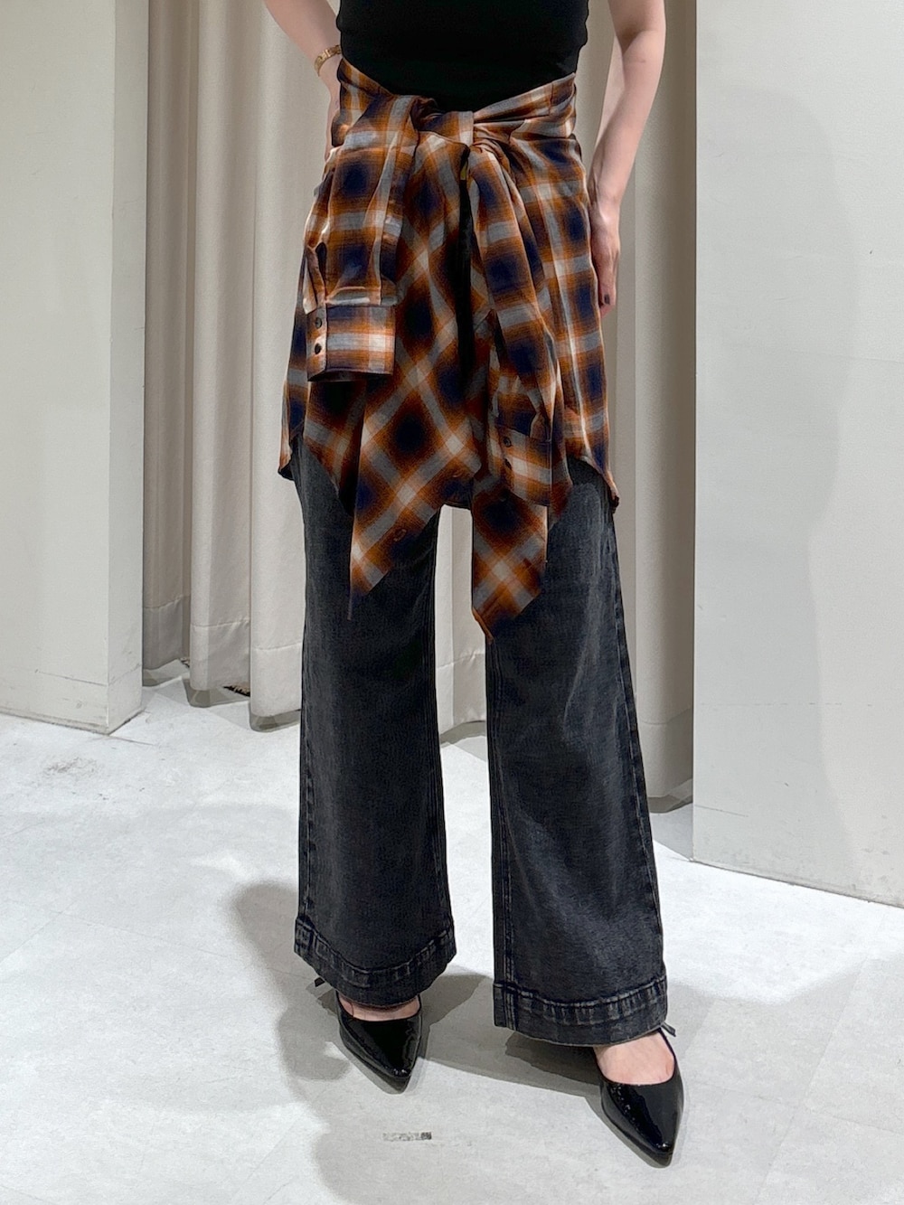 オレンジ系のシャツ/ブラウス、ブラック系のキャミソール、ブラック系のデニムパンツを着用したレディースの秋コーディネートの7枚目の写真