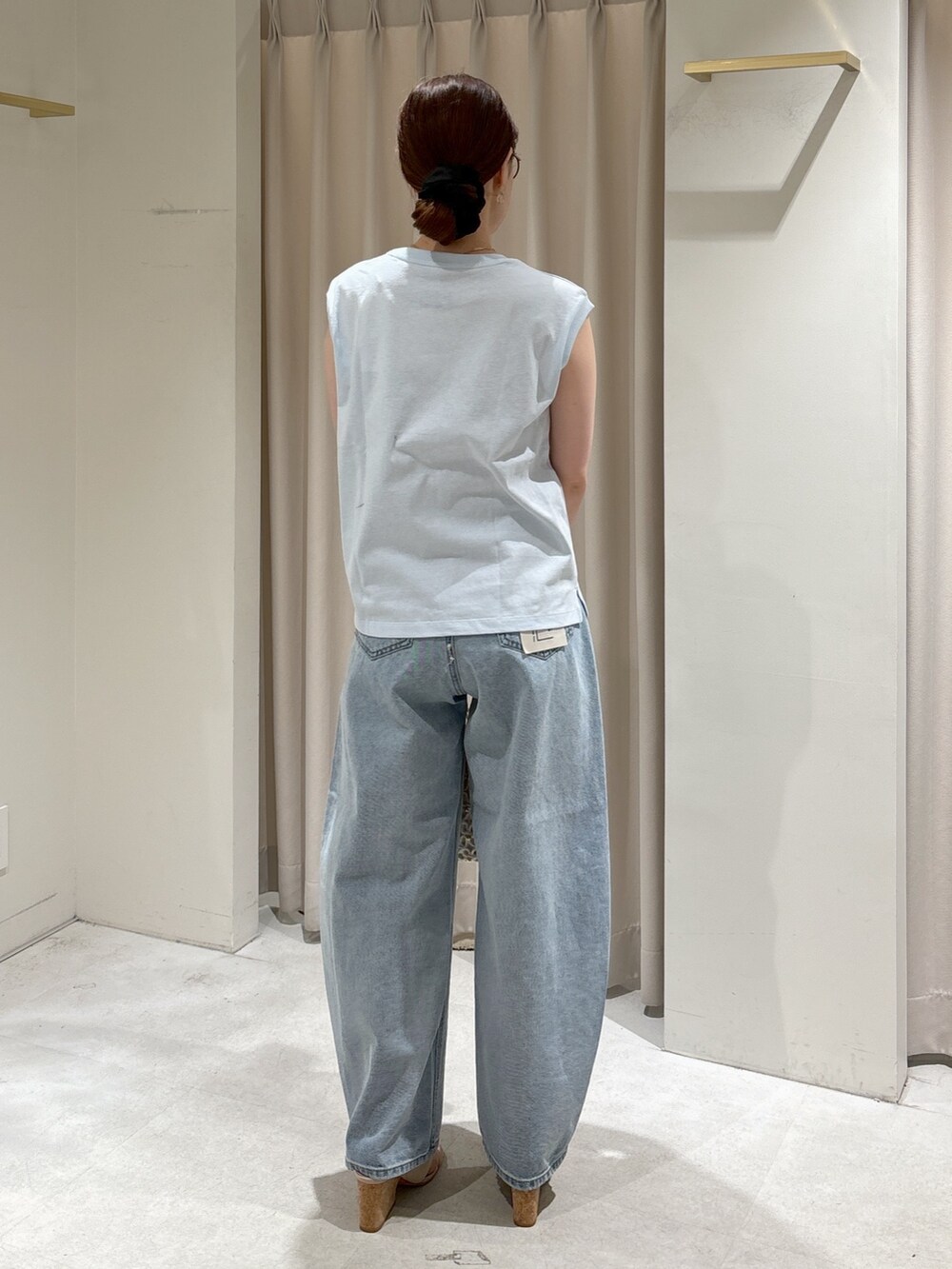 ブルー系のTシャツ/カットソー、ブルー系のデニムパンツ、ホワイト系のハンドバッグを着用したレディースの春コーディネートの4枚目の写真