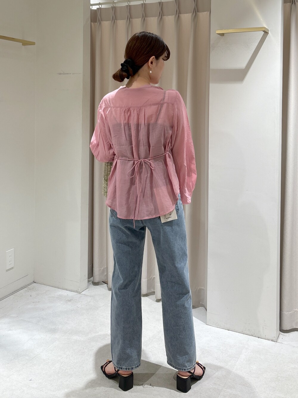 ピンク系のシャツ/ブラウス、イエロー系のかごバッグ、ブルー系のデニムパンツを着用したレディースの春コーディネートの3枚目の写真