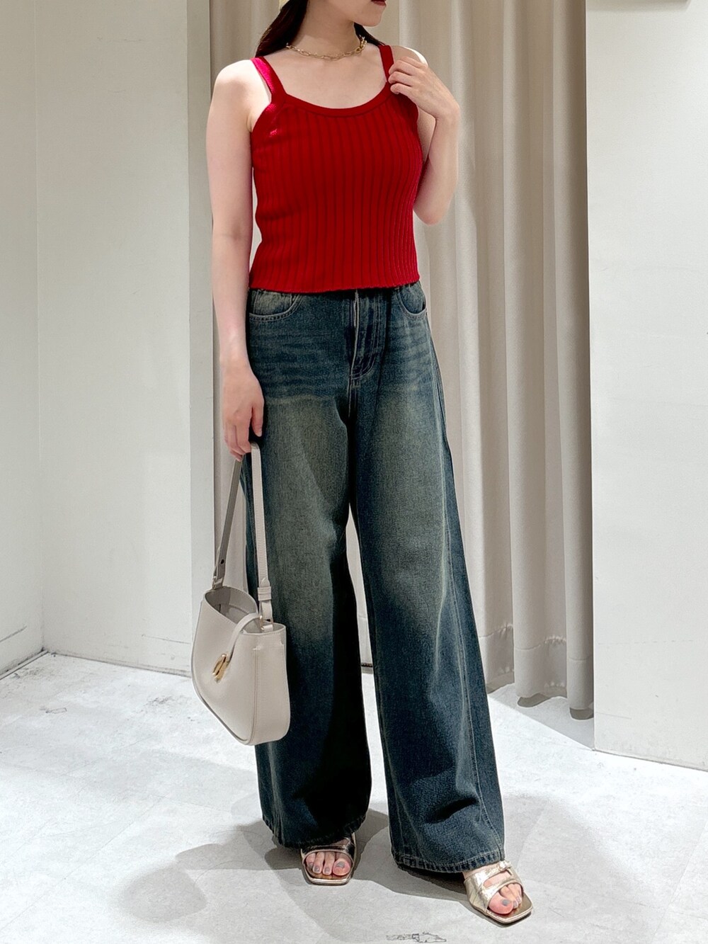 レッド系のタンクトップ、ブルー系のデニムパンツ、グレー系のショルダーバッグを着用したレディースの夏コーディネートの8枚目の写真