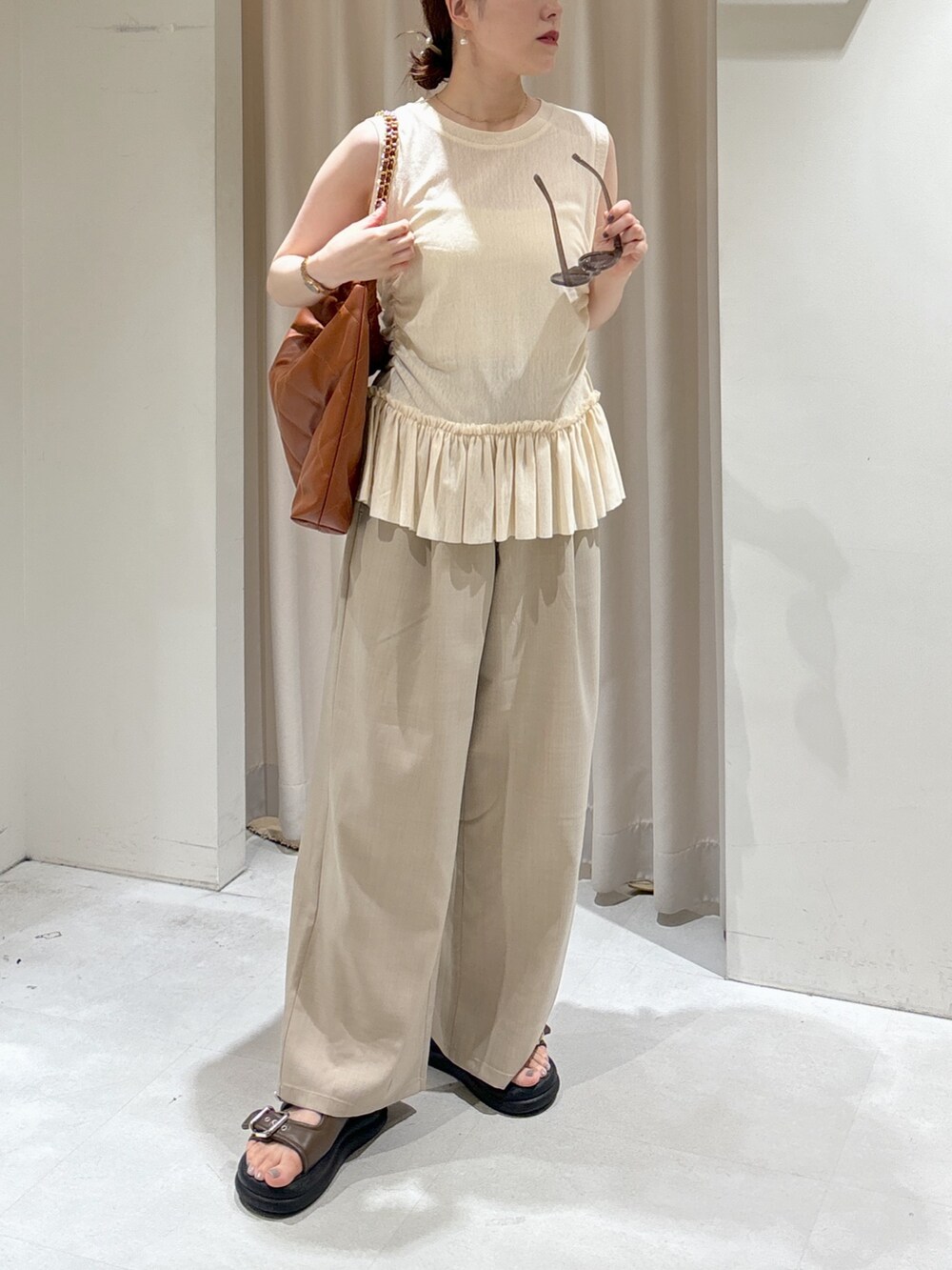 イエロー系のTシャツ/カットソー、ホワイト系のキャミソール、ブラウン系のトートバッグを着用したレディースの夏コーディネートの3枚目の写真