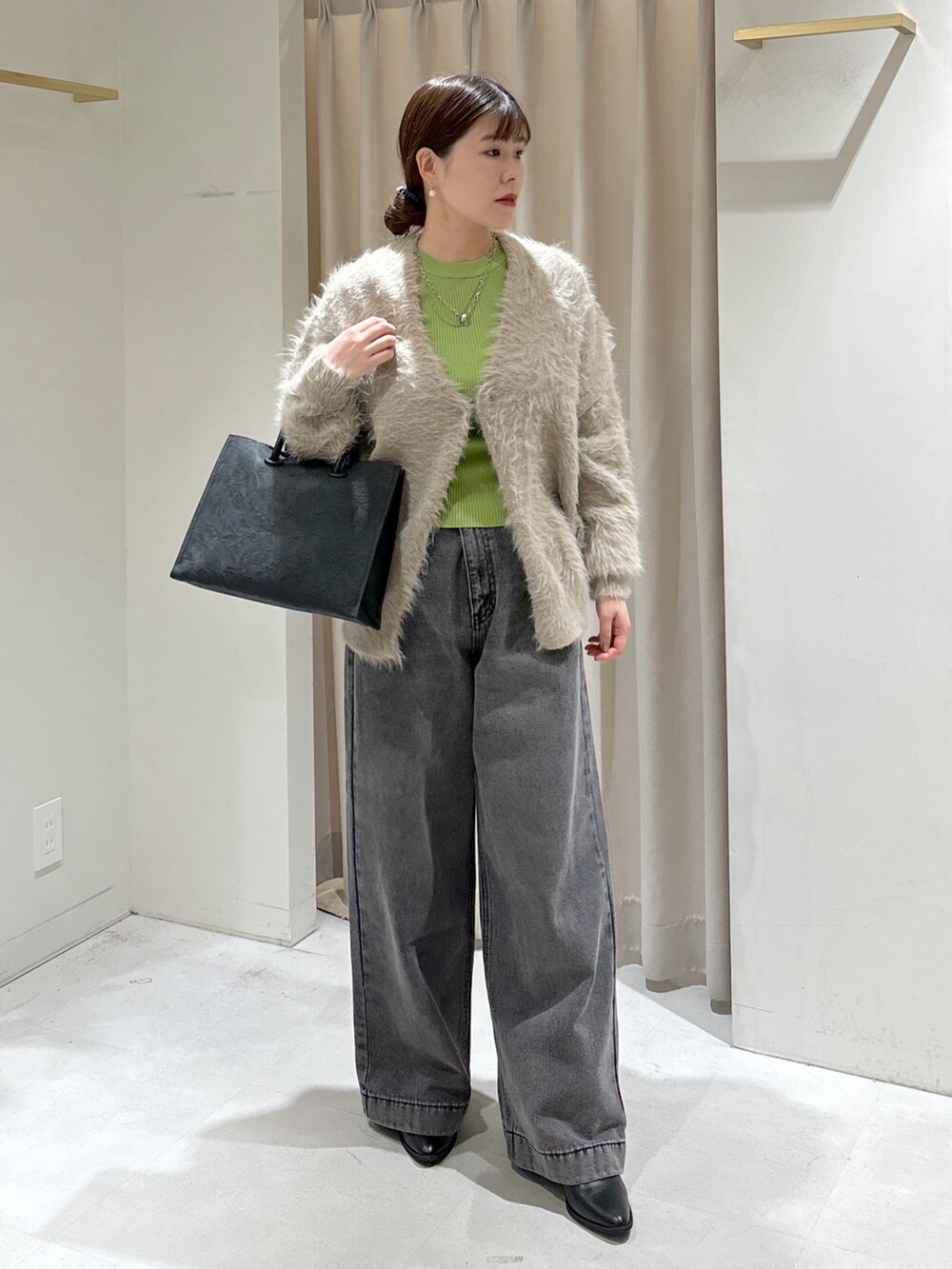 ベージュ系のカーディガン/ボレロ、ブラック系のデニムパンツ、ブラック系のトートバッグを着用したレディースの冬コーディネートの7枚目の写真