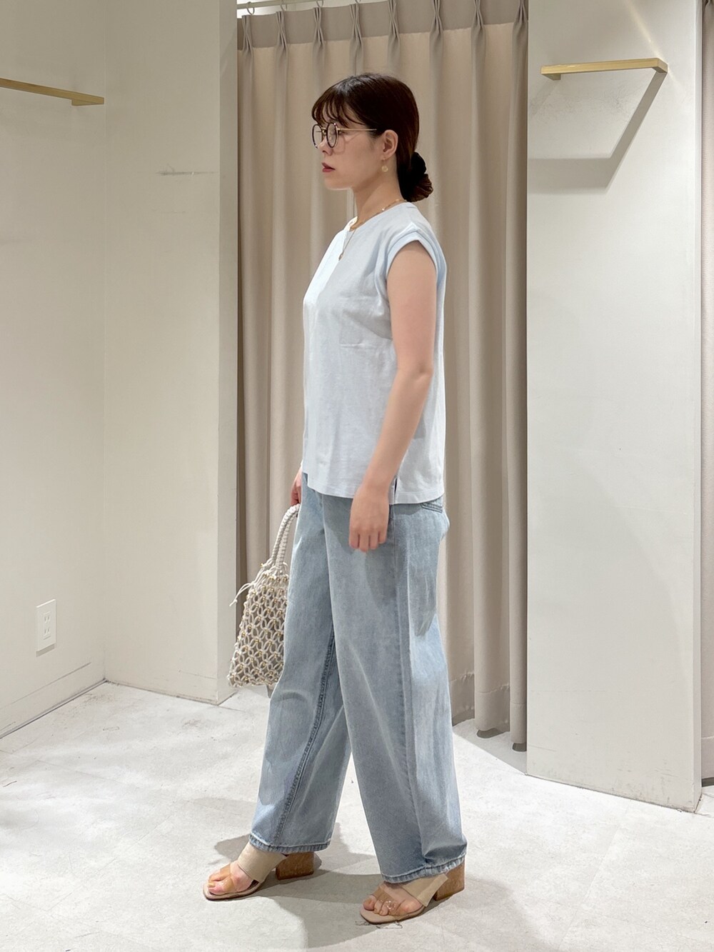 ブルー系のTシャツ/カットソー、ブルー系のデニムパンツ、ホワイト系のハンドバッグを着用したレディースの春コーディネートの5枚目の写真