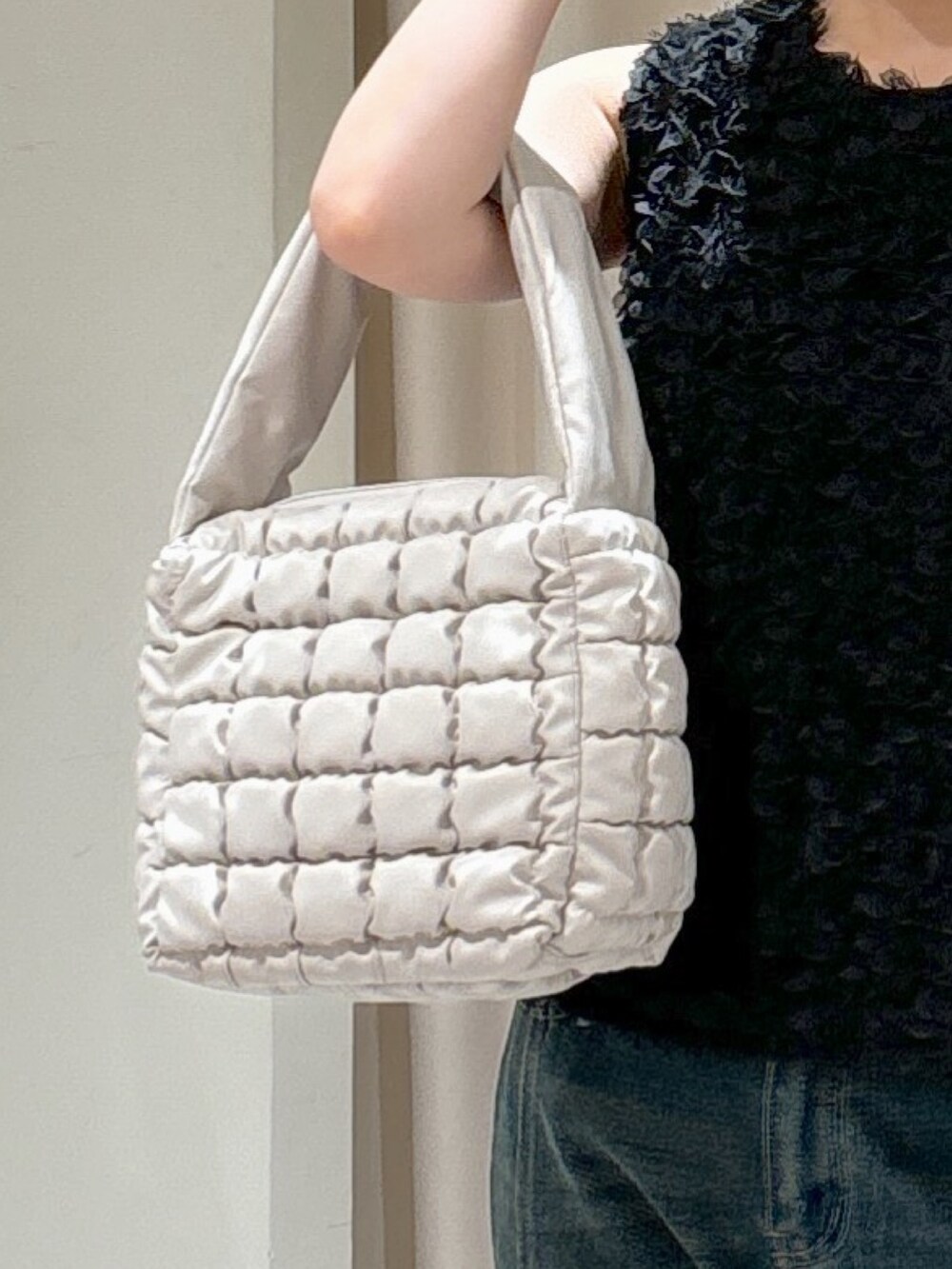 ブラック系のシャツ/ブラウス、ホワイト系のハンドバッグ、ブルー系のデニムパンツを着用したレディースの秋コーディネートの6枚目の写真