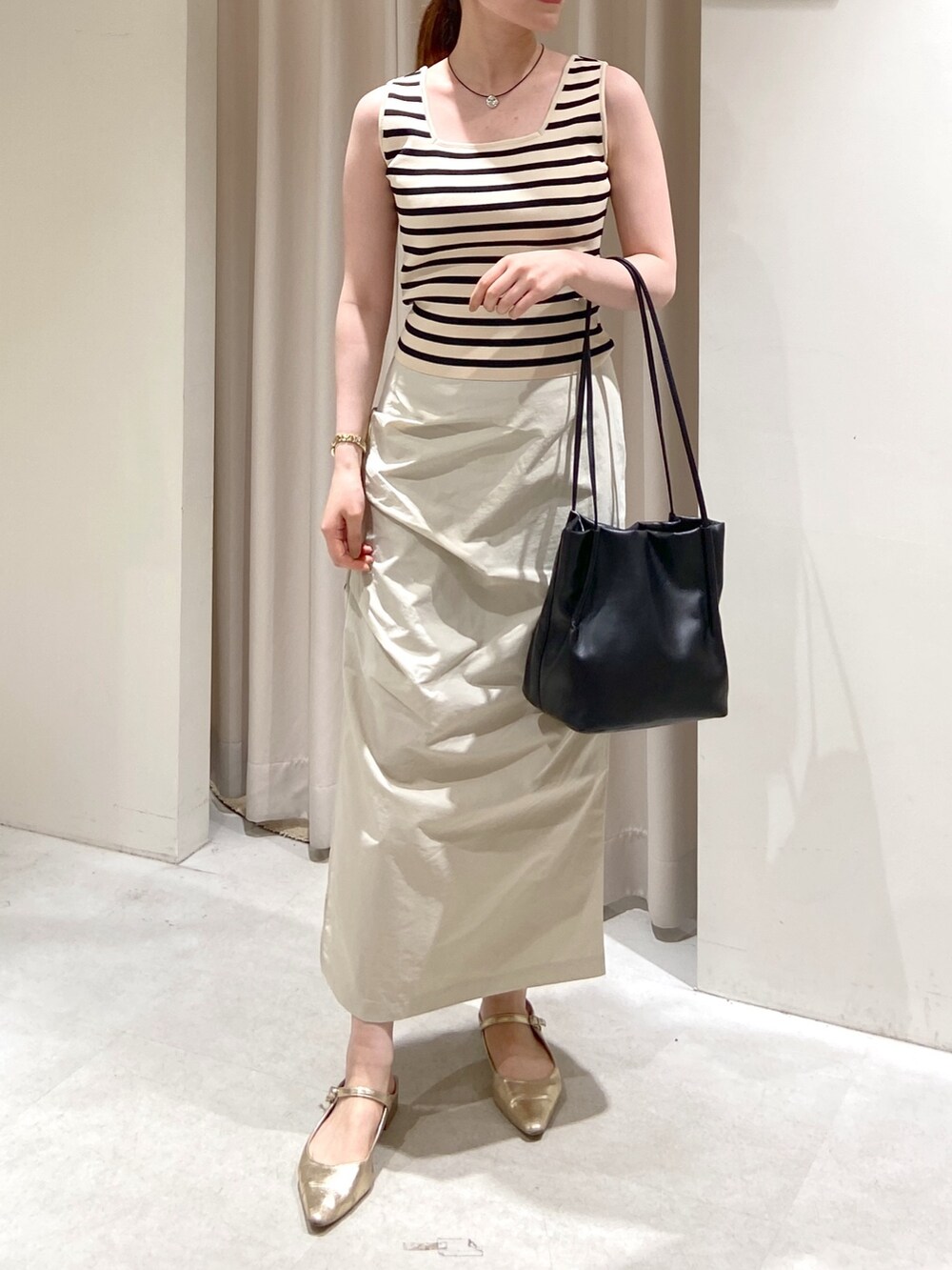 イエロー系のカーディガン/ボレロ、ホワイト系のタンクトップ、ベージュ系のスカートを着用したレディースの春コーディネートの4枚目の写真