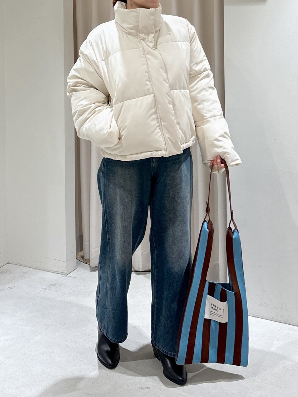 ホワイト系のブルゾン、グリーン系のニット/セーター、ブラウン系のショルダーバッグを着用したレディースの冬コーディネートの5枚目の写真