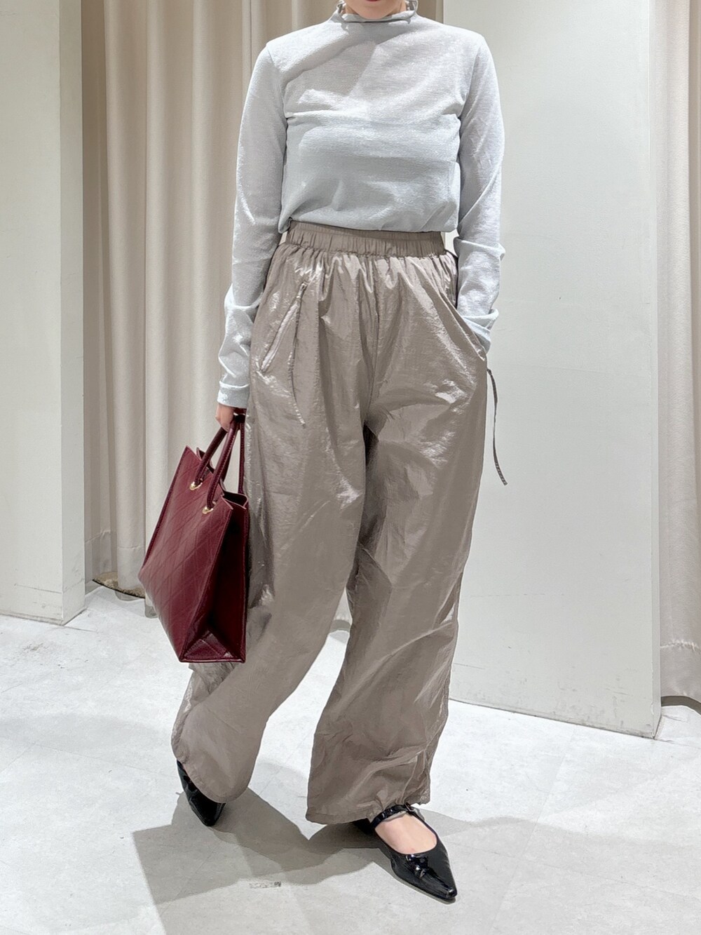 ホワイト系のニット/セーター、グレー系のTシャツ/カットソー、レッド系のショルダーバッグを着用したレディースの秋コーディネートの4枚目の写真