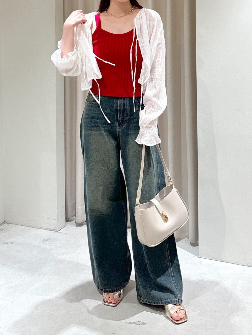 レッド系のタンクトップ、ブルー系のデニムパンツ、グレー系のショルダーバッグを着用したレディースの夏コーディネートの2枚目の写真