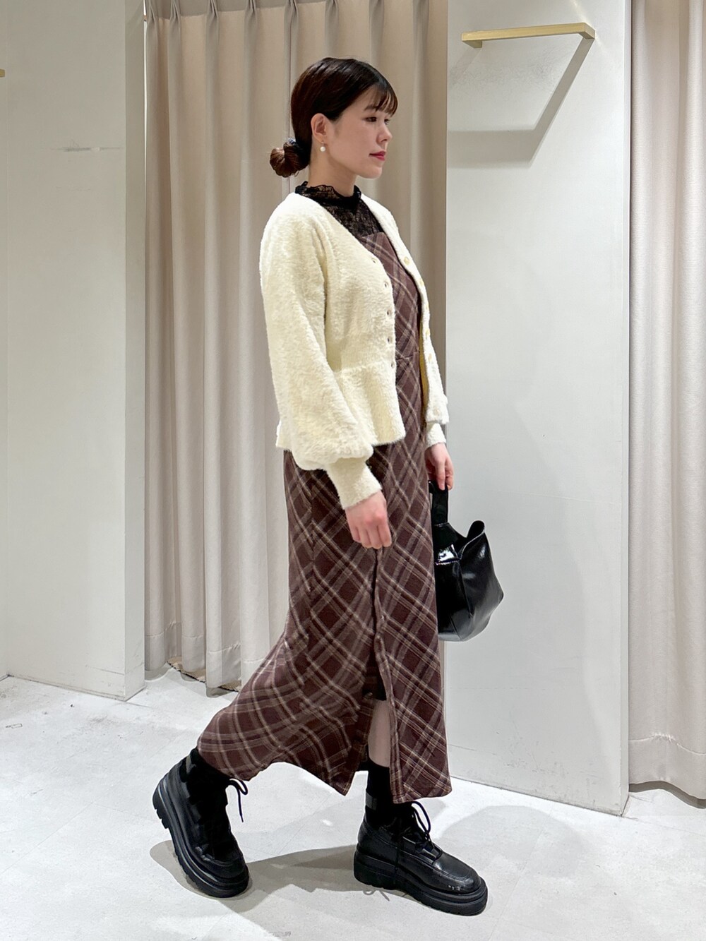 ブラウン系のワンピース、ホワイト系のカーディガン/ボレロ、ブラック系のTシャツ/カットソーを着用したレディースの冬コーディネートの2枚目の写真