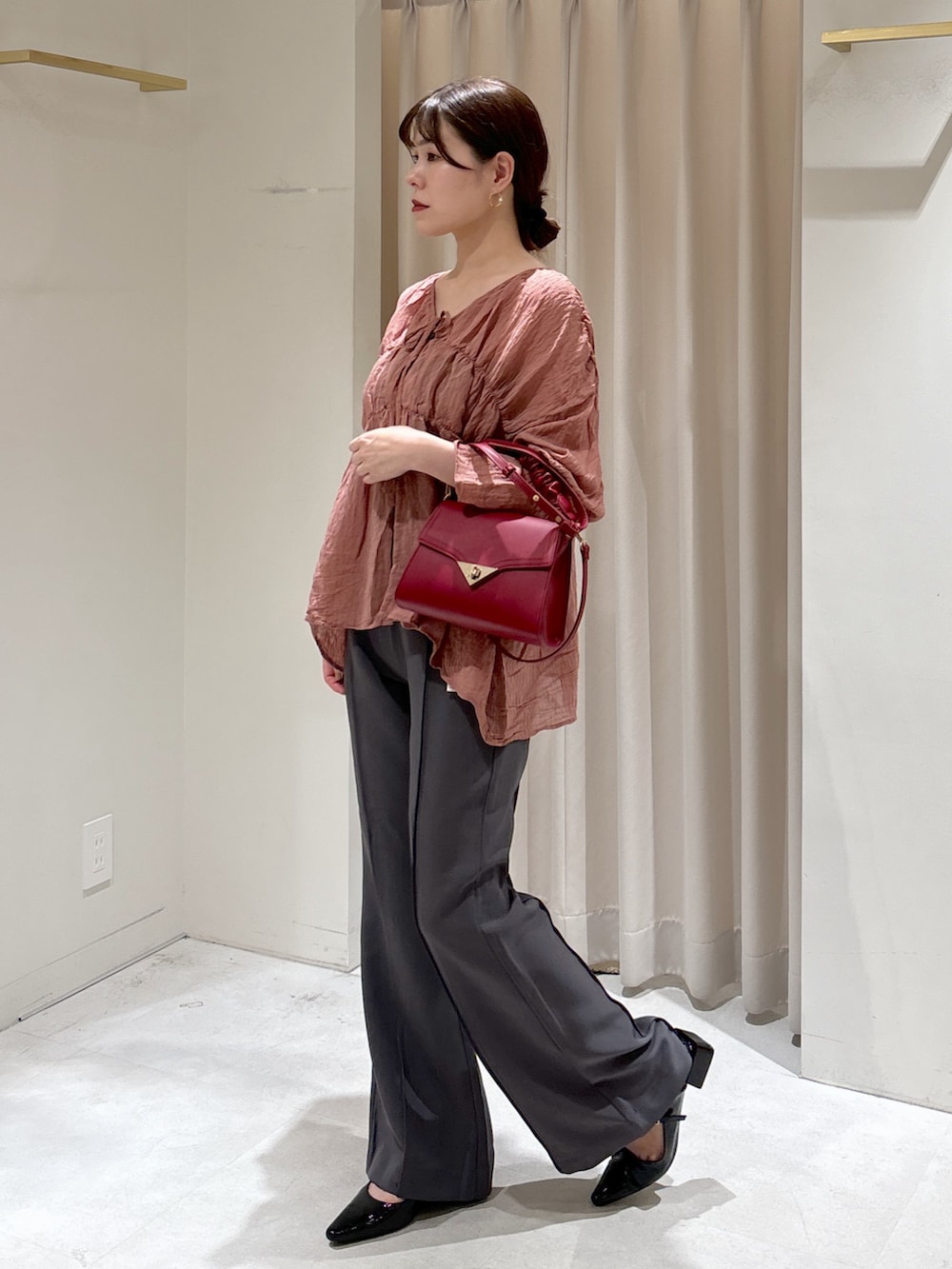 ブラック系のシャツ/ブラウス、レッド系のショルダーバッグ、グレー系のスラックスを着用したレディースの秋コーディネートの3枚目の写真