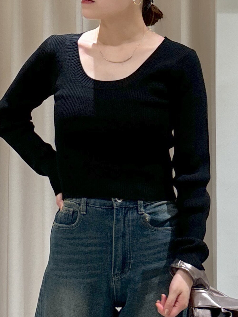 ホワイト系のシャツ/ブラウス、ブラック系のニット/セーター、シルバー系のハンドバッグを着用したレディースの秋コーディネートの4枚目の写真