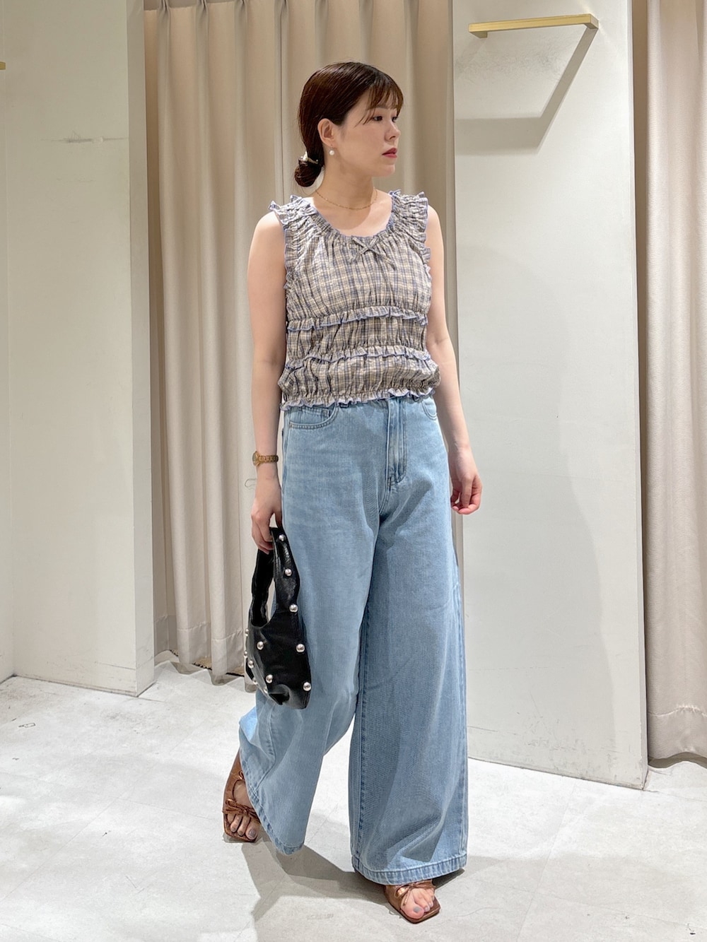 レッド系のシャツ/ブラウス、ブルー系のデニムパンツ、ブラック系のハンドバッグを着用したレディースの夏コーディネートの2枚目の写真