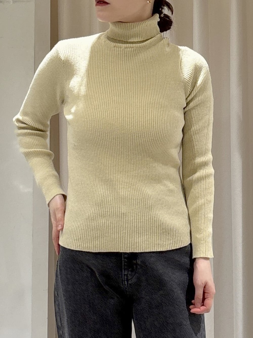 イエロー系のニット/セーター、ホワイト系のトートバッグ、ブラック系のデニムパンツを着用したレディースの秋コーディネートの5枚目の写真