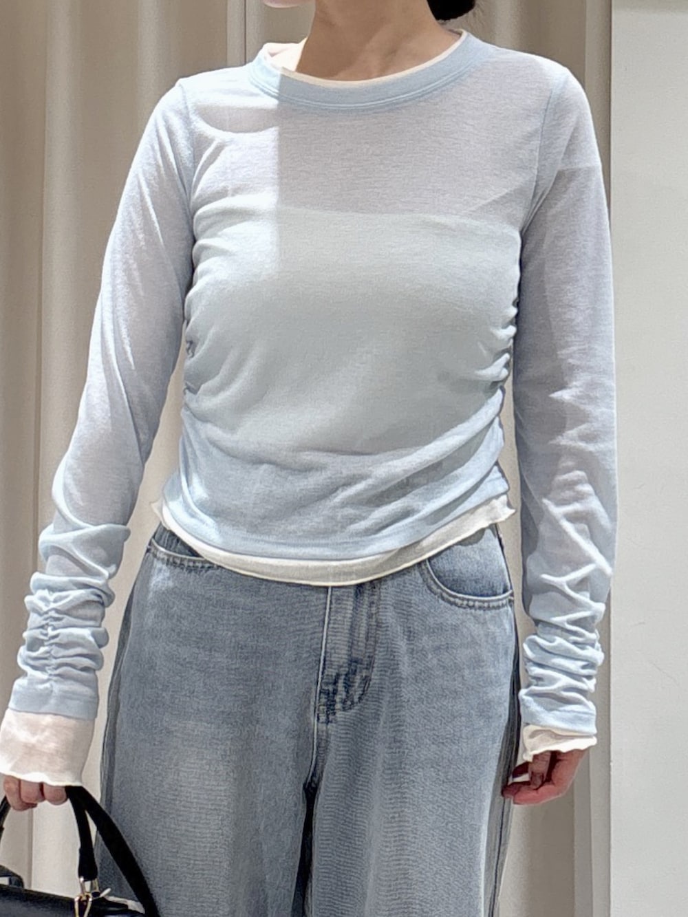 ブラック系のトートバッグ、ブルー系のデニムパンツ、ブラック系のパンプスを着用したレディースの冬コーディネートの2枚目の写真