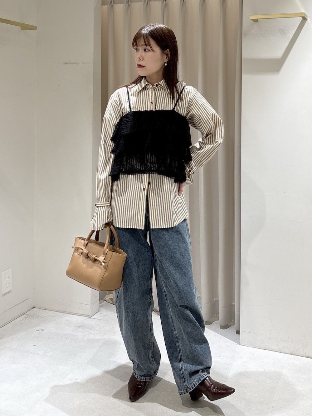 ブラック系のシャツ/ブラウス、ブラウン系のシャツ/ブラウス、ベージュ系のハンドバッグを着用したレディースの冬コーディネートの4枚目の写真