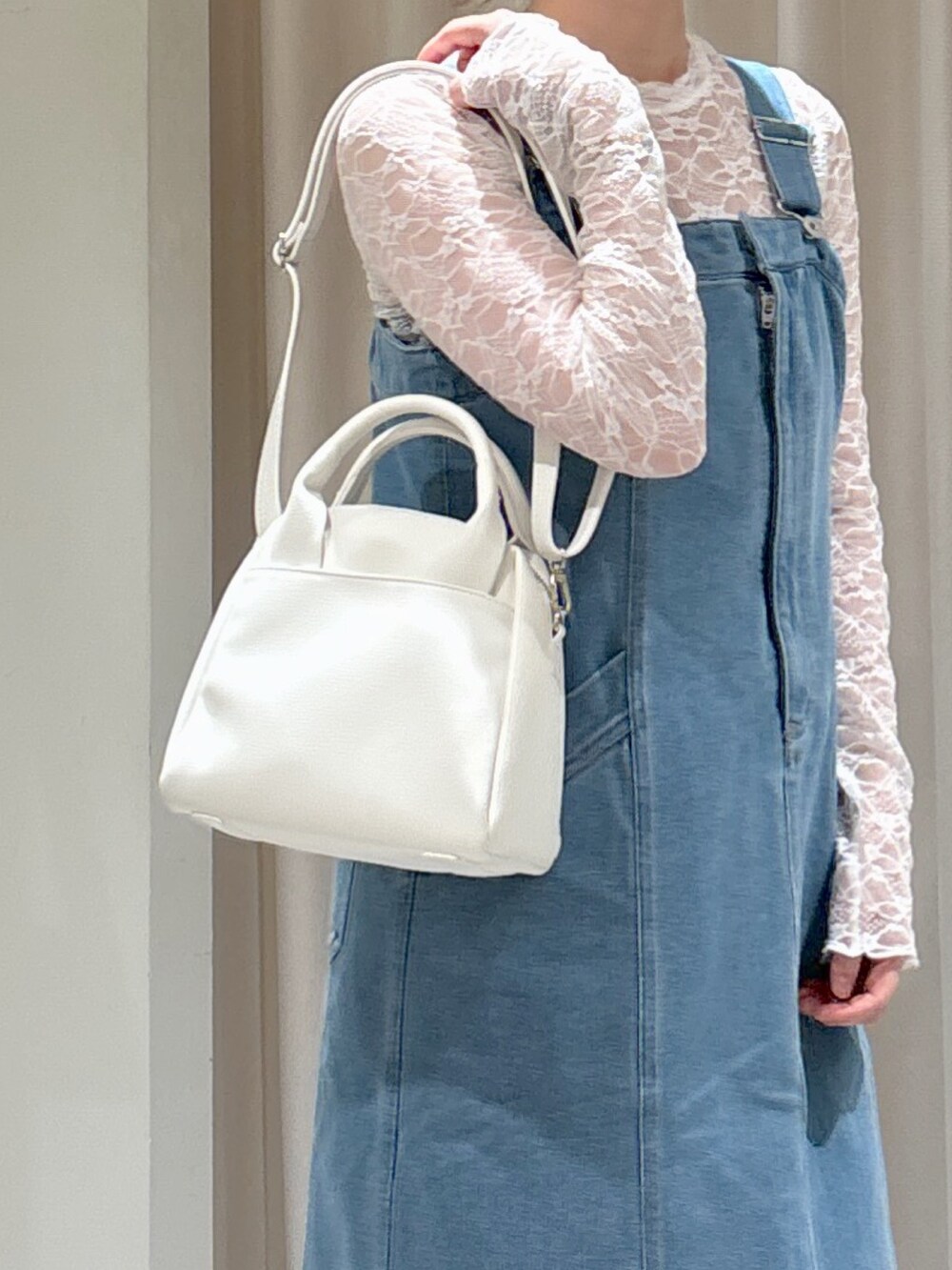 ブルー系のジャンパースカート、ホワイト系のTシャツ/カットソー、ブラウン系のサンダルを着用したレディースの春コーディネートの6枚目の写真